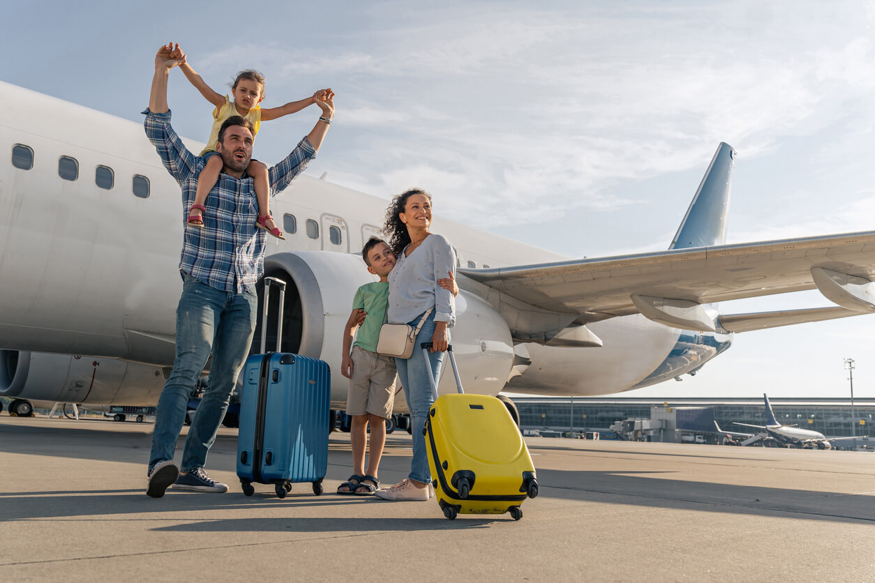 Happy family at the airport ready to travel, representing travel benefits and travel insurance services - Cardinal Life.